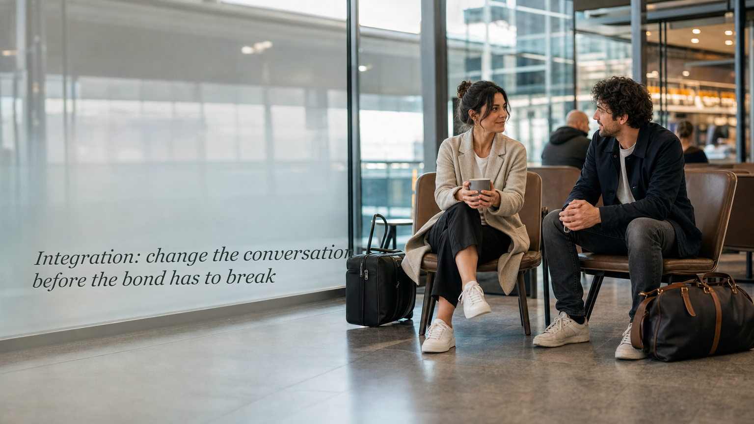 Two people talking in a travel lounge with integration guidance written on the glass wall